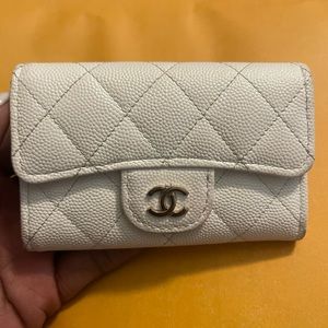 White Chanel caviar flap card holder with gold CC and exterior pocket.